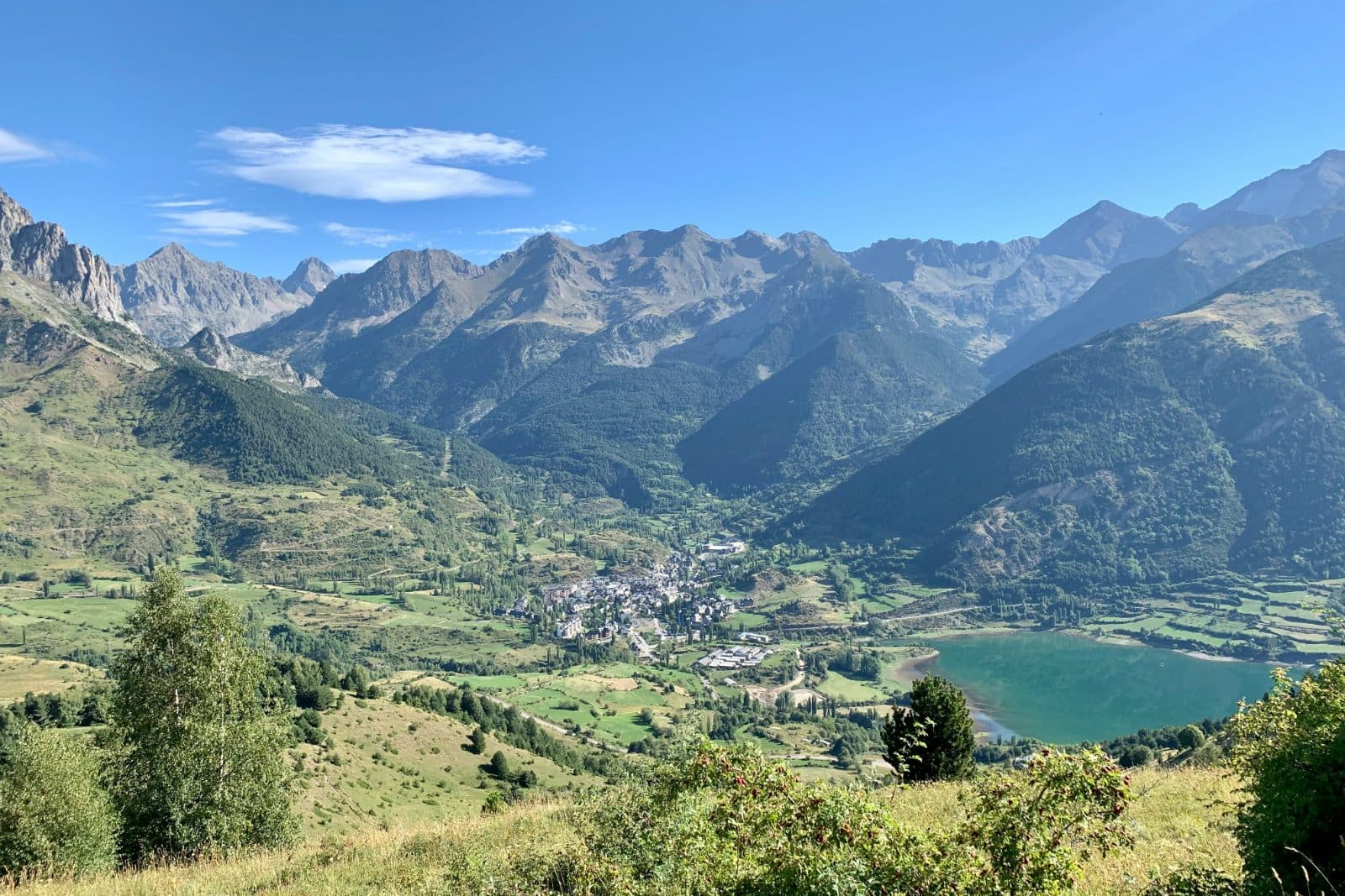 Village et lac au creux d'une vallée de montagne en été